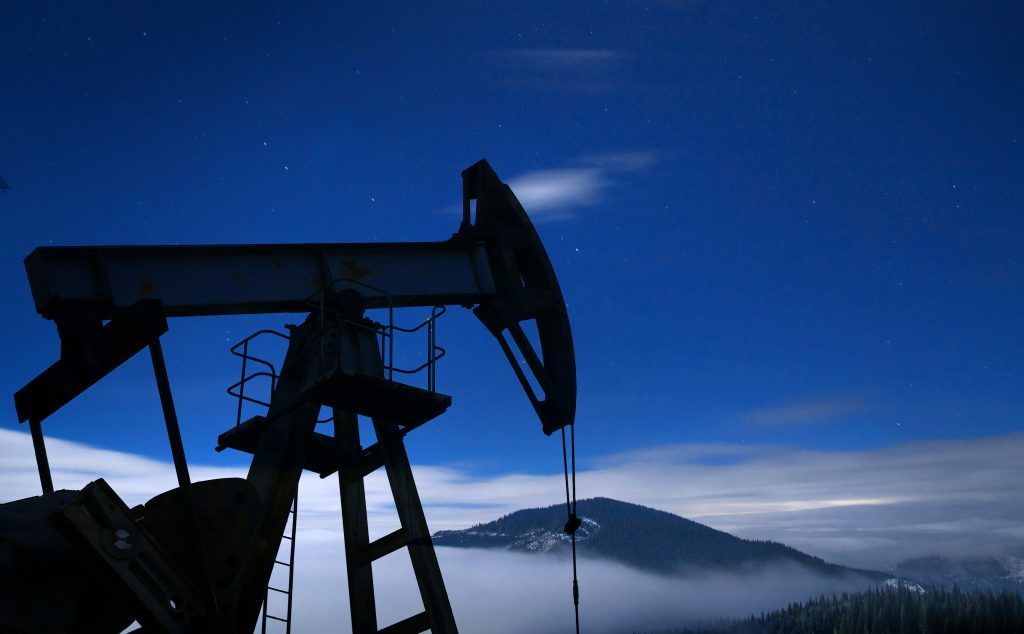 Silueta de la bomba de petroleo por la noche.